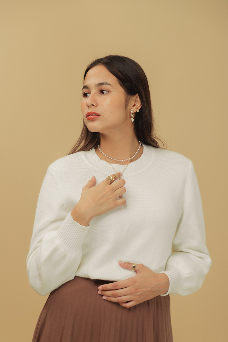 Woman in White Sweater and Brown Skirt on Beige Background